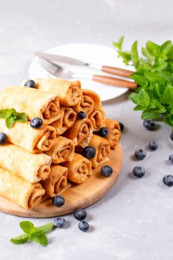 Süzme peynirli krep ve tahta tahtada taze meyve.