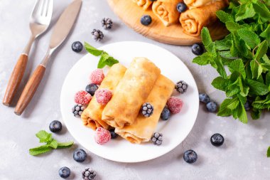 Doldurulmuş ince krepler. Yakın plan, süzme peynirli krep, meyveli, en iyi manzara.