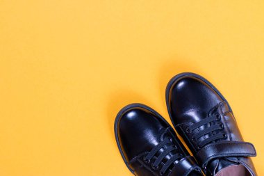 Renkli arka planda siyah ayakkabılar ve çalar saat. Düz konum, üst görünüm modayı. Moda blogu görünümü.