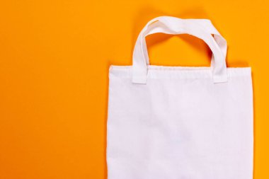 Turuncu arka planda yeniden kullanılabilir tekstil torbası. Yeniden kullanılabilir eko torbalar. Çevre dostu kavram. Üst Manzara. Boşluğu kopyala.