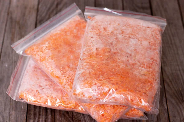 Masadaki plastik torbalarda donmuş balkabağı. Dondurucuda dondurulmuş yiyecek var.