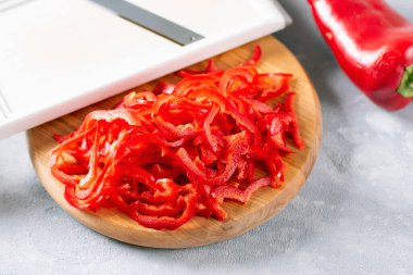 Kırmızı biber dilimleri arka planda bir kesim tahtasının üzerinde. Boşluğu kopyala.