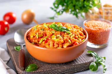 Mercimek, havuç, sebze ve fesleğenli çorba, bir tabakta.