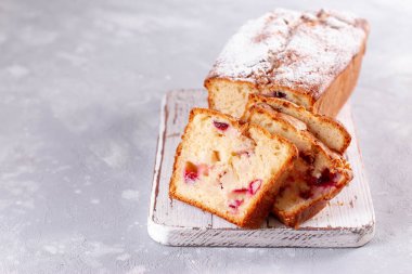 Erikli pandispanya ve açık arkaplanlı tahta üzerinde pudra şekerli elmalar. Ev yapımı pişirme..