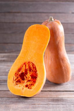 Eski ahşap arka planda dilimlenmiş tereyağı ezmesi. Tereyağlı kabak ikiye bölünmüş.