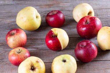 Ahşap arka planda cildinde kusurları olan çirkin, sulu elmalar. Komik, tuhaf, kusurlu meyveler. Yiyecek israfı ve çirkin gıda konsepti. Yatay yönelim bileşimi kapat.