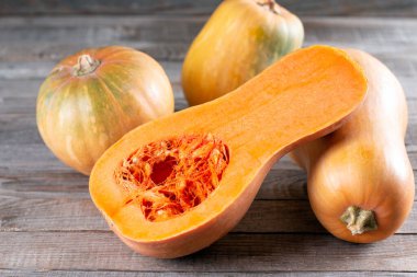 Tereyağlı kabak ikiye bölünmüş. Balkabağı, balkabağı ezmesi ahşap arka planda.