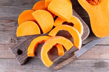 Kabak ezmesi parçaları, ahşap arka planda tahta kesme. Tatlı kış kabağı pişiriyorum.