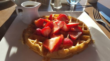 Dilimlenmiş çilek ve şuruplu Belçika Waffle 'ı