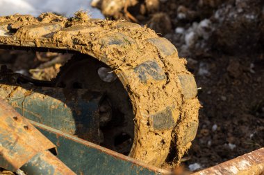 Bahçede kök söken bir kazıcı çalışıyor.