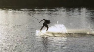 Wakeboarder günbatımı üzerinde hileler yapmak