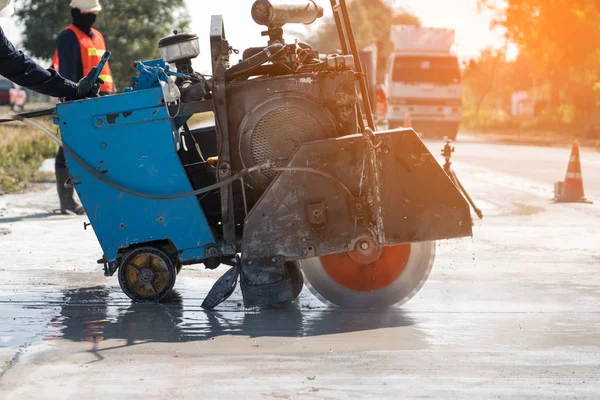 Kum kamyonuna yağmur yağarken beton yol kesiciler arka planı bulanıklaştırdı, inşaat konsepti