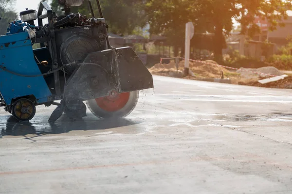 Kum kamyonuna yağmur yağarken beton yol kesiciler arka planı bulanıklaştırdı, inşaat konsepti