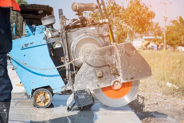 Kum kamyonuna yağmur yağarken beton yol kesiciler arka planı bulanıklaştırdı, inşaat konsepti