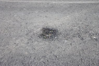 Yolda yeni asfalt üzerinde küçük bir çukur