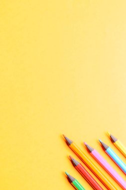 Turuncu arka planda çok renkli kalemler. Güzel sanatlar derslerinde renkli kalemlerle çizimler. Okul için hazırlık.