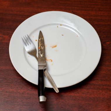 Yemekten sonra kirli tabaklar gitti. Bıçak ve çatal kirli tabakta.