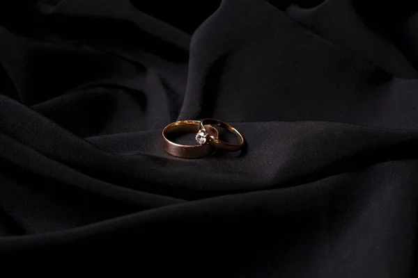 Gold wedding rings on black silk.Wedding attributes.Wedding preparation.