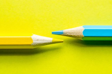 Sarı arka planda renkli kalemler..