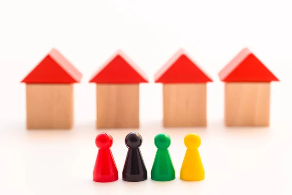 Paralel dört ahşap evin önünde duran dört meeple.