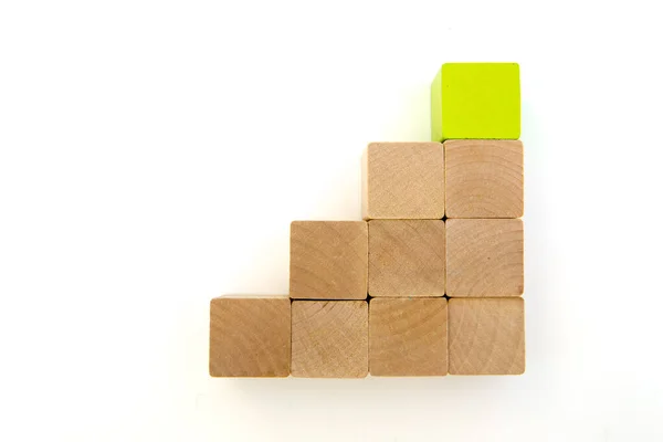 Kare tahta bloklar merdiven gibi yığılıyor. yeşil blok üstte.