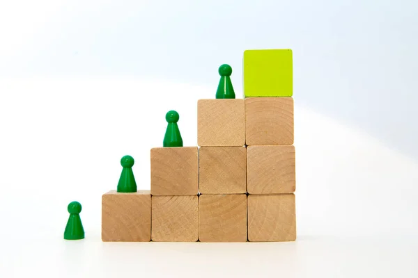 Ahşap basamaktaki yeşil meeple. yeşil blok üstte.