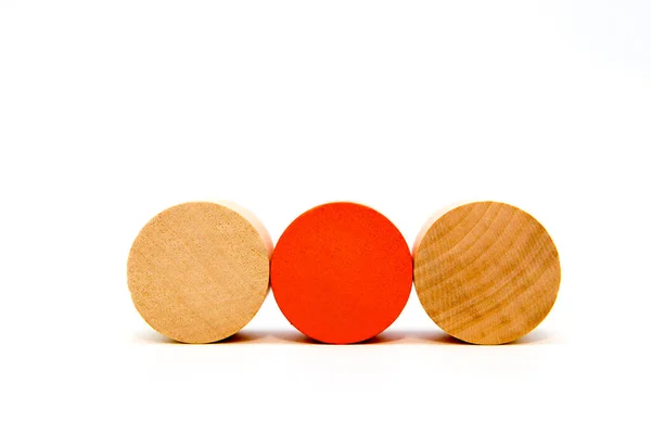 İki doğal ve bir kırmızı yuvarlak tahta oyuncak bloğu beyaz arka planda izole edilmiş.