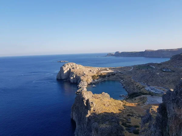 De cima tiro de água azul limpa de mar calmo perto de penhasco pedregoso áspero em dia ensolarado na bela natureza . — Fotografia de Stock