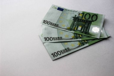 Beyaz arka planda izole edilmiş 100 Euro 'luk banknotlara yakın çekim. Para birimi, finansal