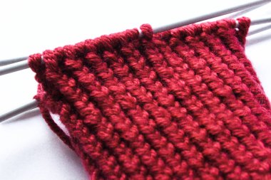 Bitmemiş örgü yünü ve örgü iğneleri projesi. Kırmızı iplik ve arapsaçı. El yapımı konsept. El işi afişi. İzole edilmiş. Yukarıdan bak. Üst Manzara. Boşluğu kopyala