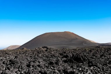 Görkemli lav nehrinin benzersiz panoramik görüntüsü dev bir volkan kraterinden akarak Dünya 'da bir ay manzarası yaratır. Ateş Dağları, Timanfaya Ulusal Parkı, Lanzarote, Kanarya Adaları, İspanya.