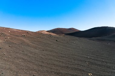 Görkemli lav kumlarının ve devasa volkan kraterinin küllerinin eşsiz panoramik görüntüsü Dünya 'da bir ay manzarası yaratır. Timanfaya Ulusal Parkı, Lanzarote, Kanarya Adaları, İspanya.