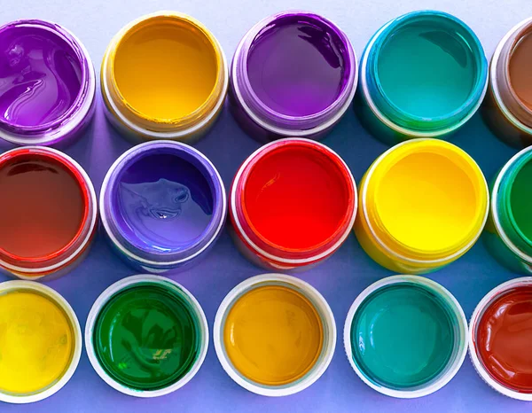 multicolored gouache paints in jars in flat lay