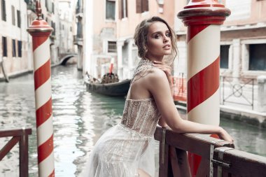 Venedik kanal yakın poz çıplak makyaj, giymiş şık, lüks Fildişi elbise ve dağınık kabarık saç modeli, güzel gelinle