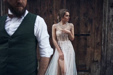 Venedik ahşap kapısı yakın poz düğün çifti. Kadın zarif lüks Fildişi elbise ve dağınık kabarık saç, papyon ile Yeşil elbiseli adam