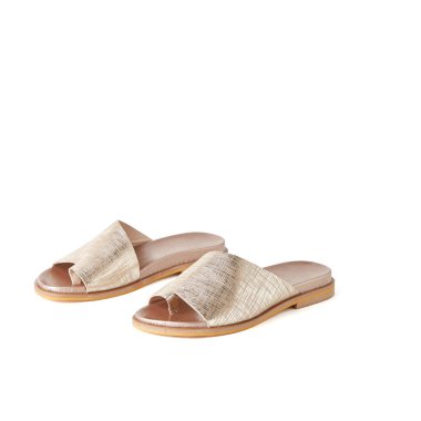 Kadının altın bir parmak düz sandaletler. Atış, beyaz arka plan stüdyo