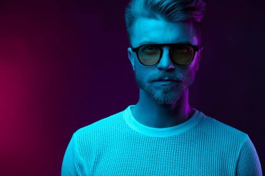 Neon ışık stüdyo portre bıyık ve sakal güneş gözlüğü ve beyaz t-shirt ile ciddi adam modelinin 