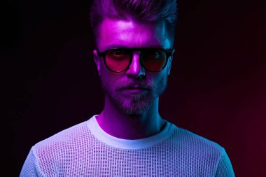 Neon ışık portre bıyık ve sakal güneş gözlüğü ve beyaz t-shirt ile ciddi adam modelinin 