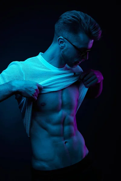 T-shirt, gösteren abs çekerek seksi kaslı adam sarı bardaklarda Neon ışık portresi