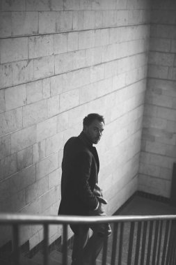 Merdivenlerde şık yakışıklı siyah beyaz portre. Adam geri kamera görünüyor 