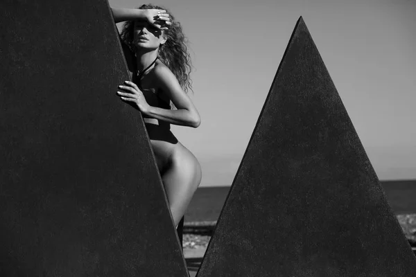 Сексуальная Модель Вьющимися Волосами Черном Бикини Стоящая Возле Скульптуры Моря — стоковое фото