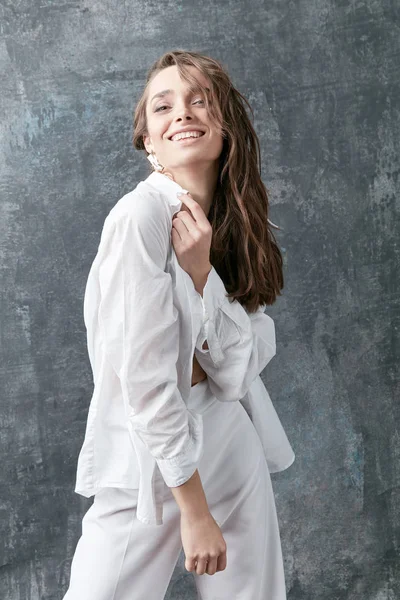 Улыбающаяся Брюнетка Модель Позирует Белой Рубашке Топе Штанах Студийный Снимок — стоковое фото