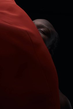 Sanat afro adam portresi. Adamın kafasının arkasında kırmızı kumaş, siyah arka plan. Karanlık anahtar. Katmanlar, çizgiler, köşegen.