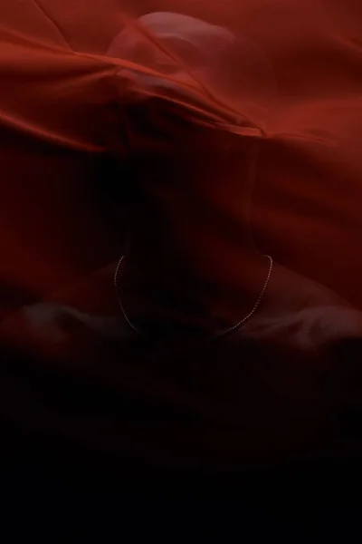 Art portrait of black man posing behind red fabric. Sensual. Art performance, acting.