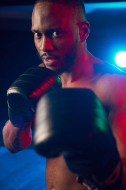 Yüzük üzerinde ciddi kas adam kamera arıyorum. Ateş, kırmızı ve mavi ışık studio.