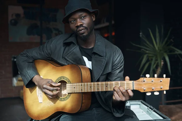 Muzikant Zwarte Regenjas Emmer Hoed Zittend Bed Gitaar Spelen Songwriter — Stockfoto