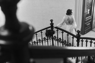 Merdivenlerde duran lüks elbisegüzel esmer gelintam uzunlukta portre. Siyah beyaz