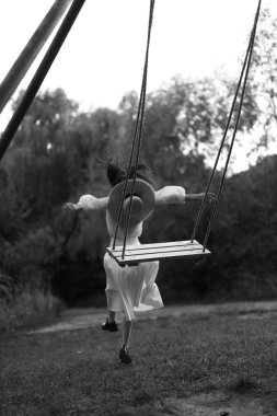 Vintage giysiler içinde güzel kadının Monokrom portre, salıncak atlama