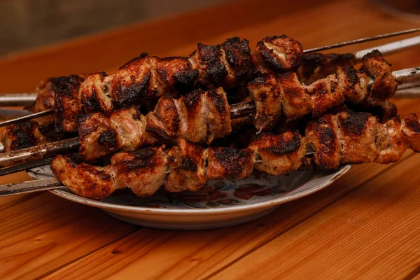 Shish kebab on a plate on a wooden table. shashlik. — Stock Photo, Image