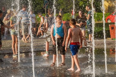 Uzhhorod, Ukrayna, 30 Haziran 2019: Çocuklar sıcak bir yaz günü çeşmede yıkanırlar.